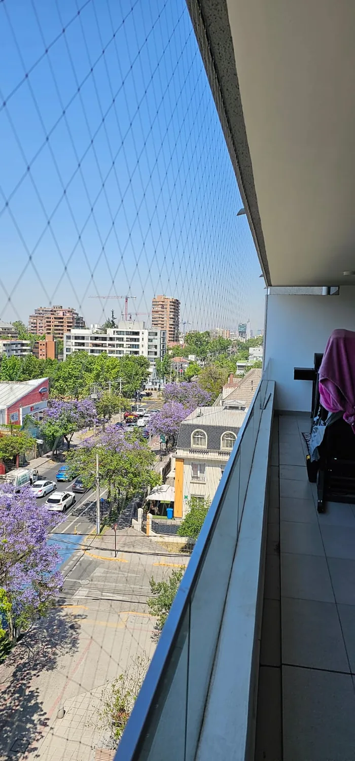 Malla de seguridad transparente instalada en un balcón alto
